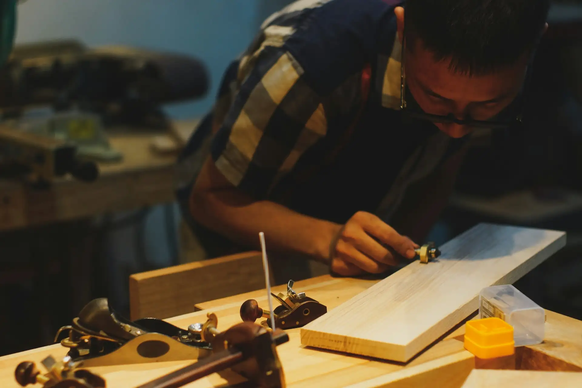 Un carpintero trabaja una pieza de madera con herramientas de mano en su taller